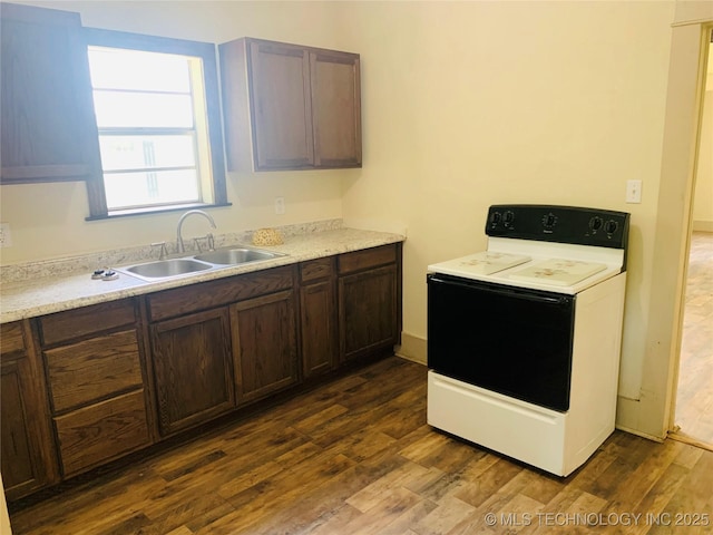 kitchen featuring electric range, dark hardwood / wood-style flooring, dark brown cabinetry, and sink