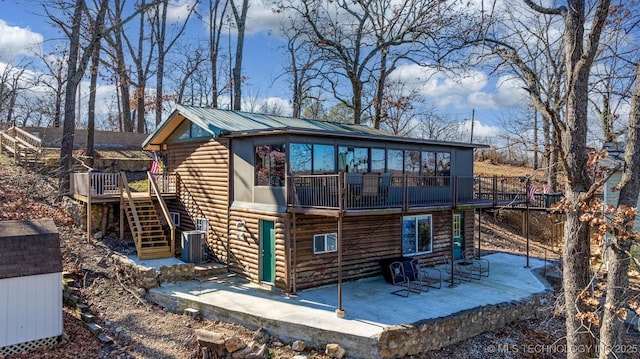 rear view of property with central AC unit, a deck, and a patio