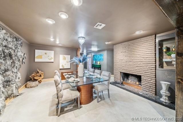 dining space featuring crown molding and a fireplace