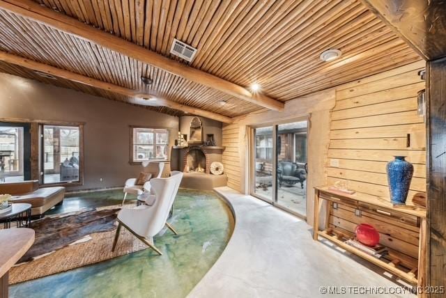 living room featuring concrete flooring, vaulted ceiling with beams, wooden walls, and wooden ceiling