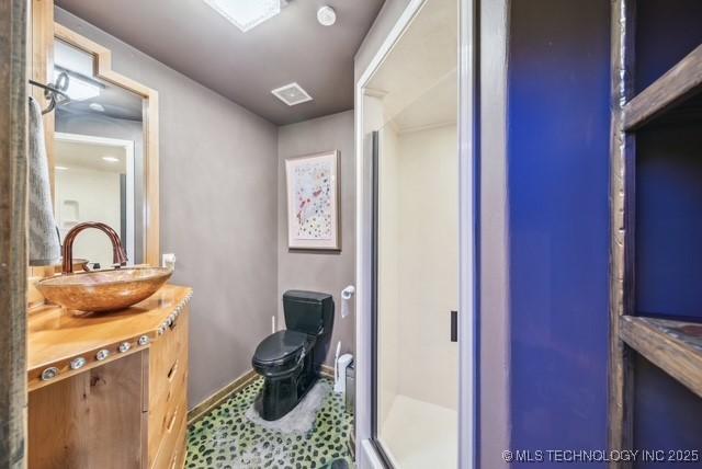 bathroom with vanity, toilet, and a shower with shower door