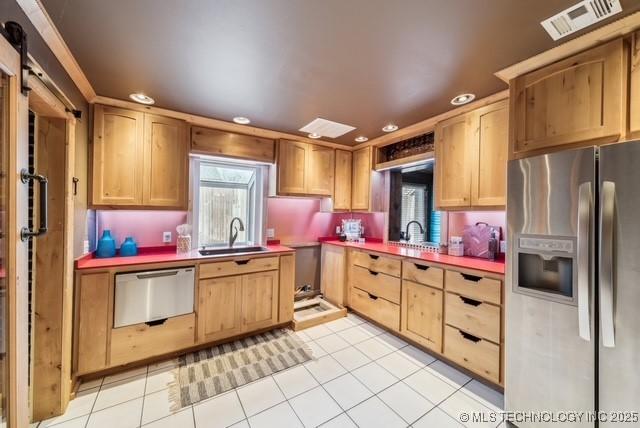 kitchen with sink, light tile patterned flooring, and appliances with stainless steel finishes