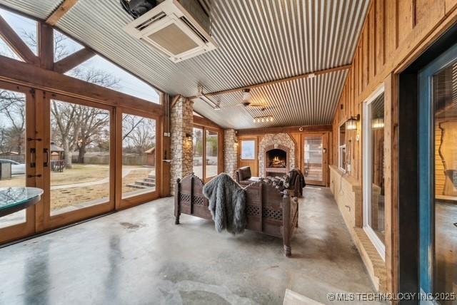 unfurnished sunroom featuring a fireplace and vaulted ceiling