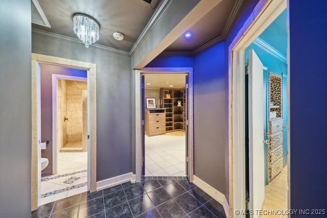 corridor featuring crown molding and an inviting chandelier