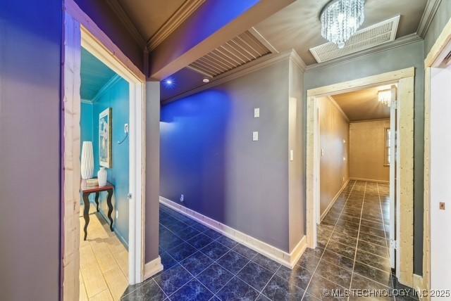 hall featuring a chandelier and crown molding