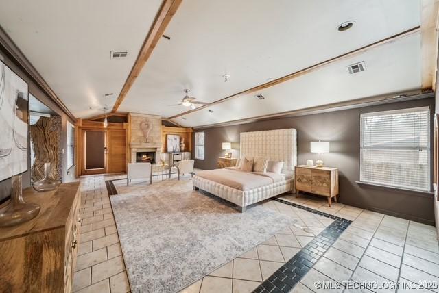 tiled bedroom with a fireplace and lofted ceiling with beams