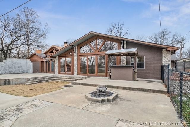 rear view of house with a patio area and an outdoor bar