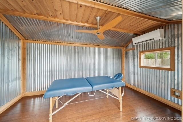 game room featuring vaulted ceiling, ceiling fan, wood-type flooring, and a wall mounted air conditioner