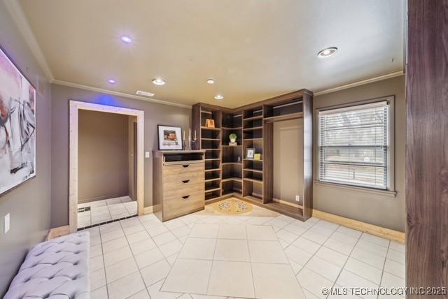 interior space with light tile patterned floors and ornamental molding