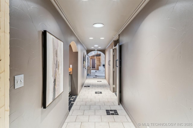 corridor with light tile patterned flooring and crown molding