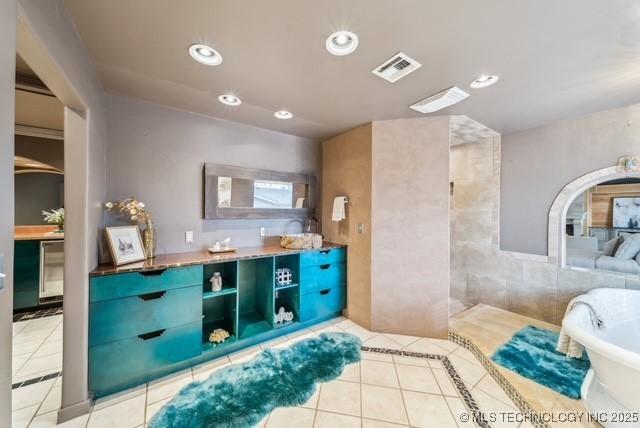 bathroom with tile patterned floors, vanity, and a tub