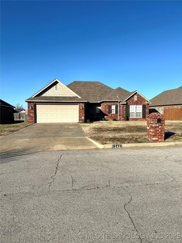 view of front of property with an attached garage, concrete driveway, and brick siding