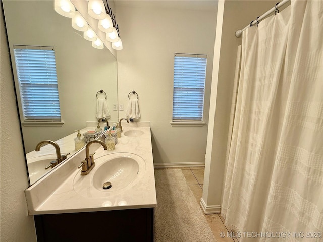 full bath featuring double vanity, a sink, and tile patterned floors