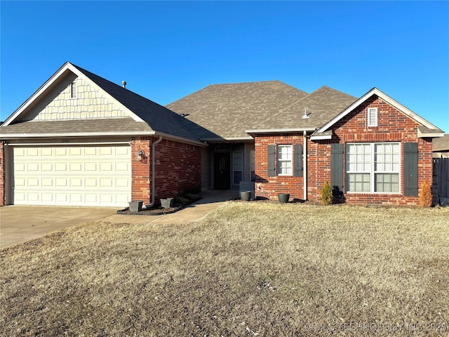 view of front of home featuring an attached garage, brick siding, driveway, roof with shingles, and a front lawn