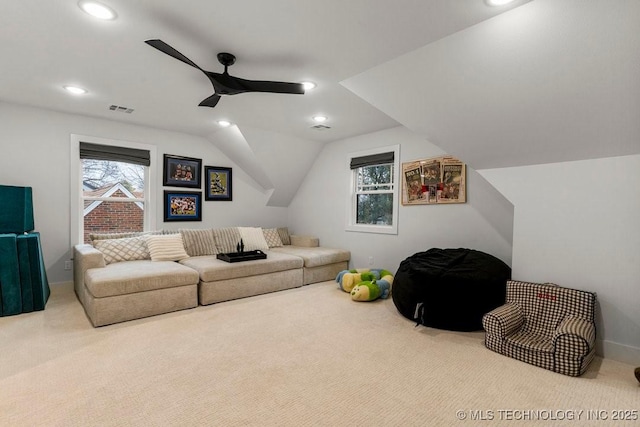 living room featuring ceiling fan, light carpet, and vaulted ceiling