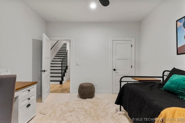 bedroom with baseboards and light carpet