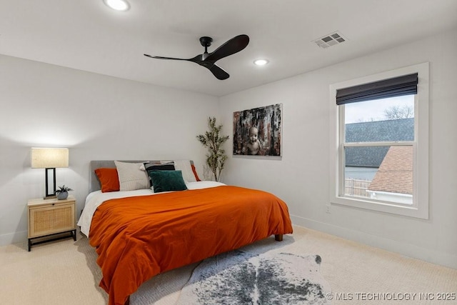 bedroom featuring multiple windows, light colored carpet, and ceiling fan