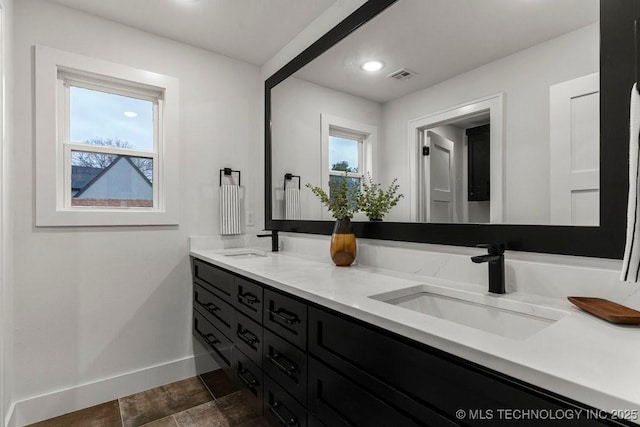bathroom with a sink, visible vents, and plenty of natural light
