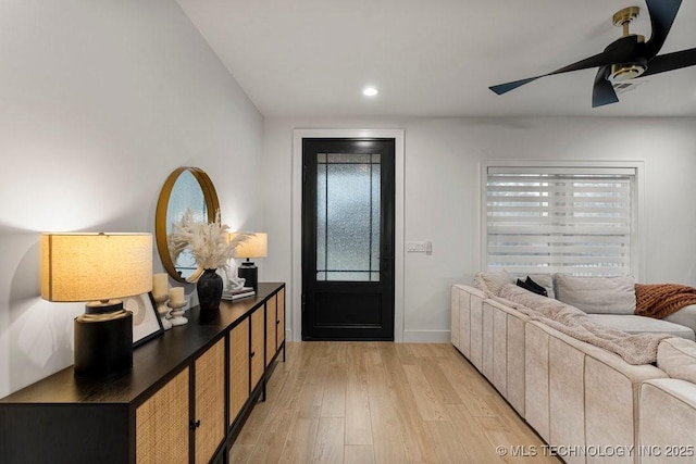 foyer entrance with ceiling fan and light wood-type flooring