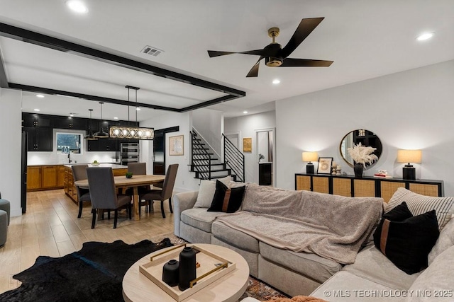 living room featuring beamed ceiling, ceiling fan, and light hardwood / wood-style floors