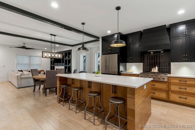 kitchen with custom exhaust hood, light wood finished floors, beam ceiling, and appliances with stainless steel finishes