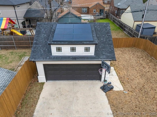 exterior space with a garage and solar panels