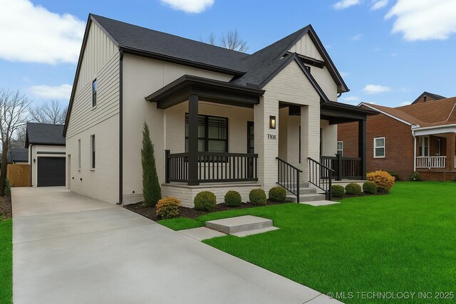 view of front of home featuring board and batten siding, covered porch, an outdoor structure, a front lawn, and a garage
