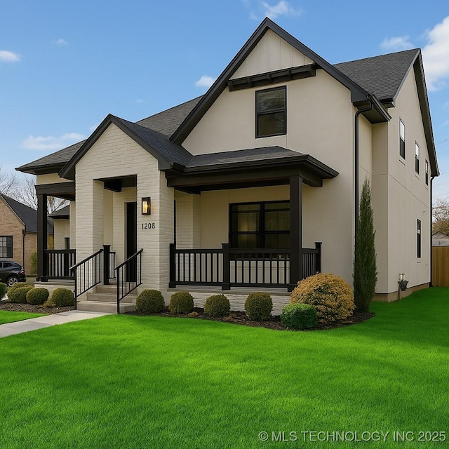 view of front of property featuring a front yard, brick siding, stucco siding, and a porch