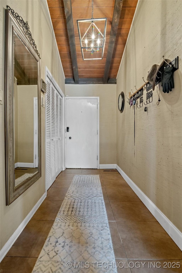 doorway with tile patterned floors, a notable chandelier, beam ceiling, and wood ceiling