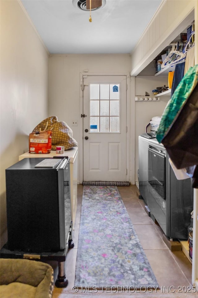 laundry area with light tile patterned floors and separate washer and dryer