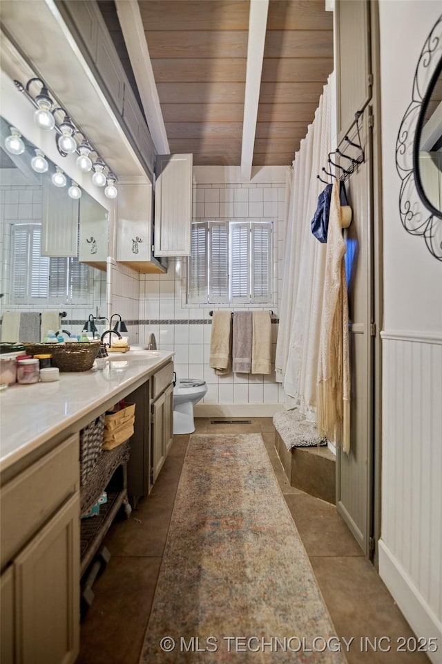 bathroom featuring beamed ceiling, tile patterned floors, toilet, vanity, and wood ceiling