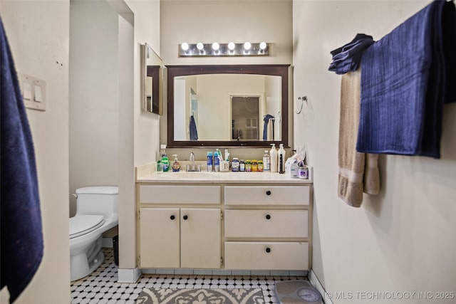 bathroom featuring tile patterned flooring, vanity, and toilet