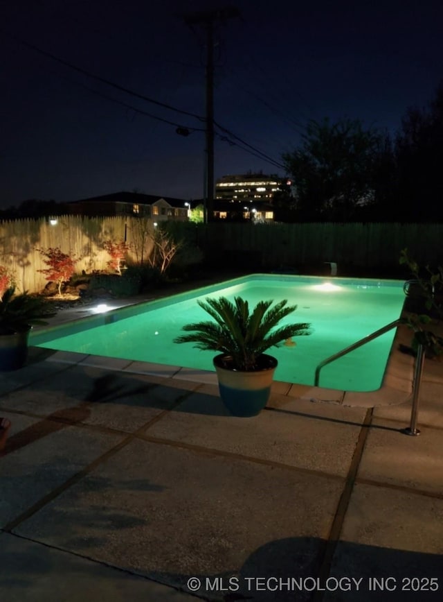 view of pool at twilight