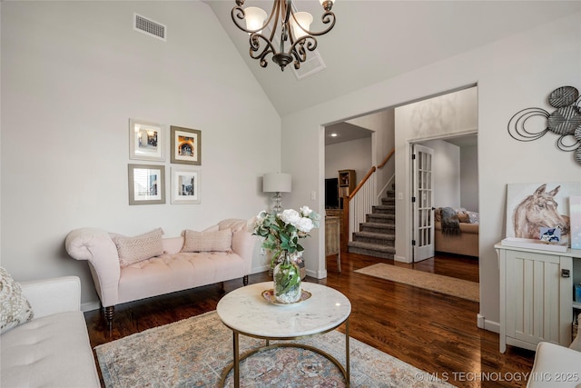 living room with high vaulted ceiling, a chandelier, and dark hardwood / wood-style floors