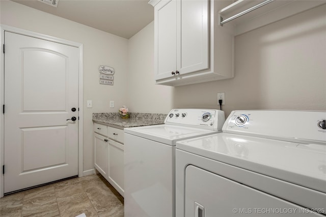 clothes washing area with cabinets and washing machine and dryer