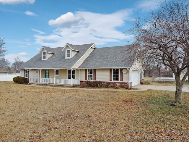 new england style home with a front yard, a porch, and a garage