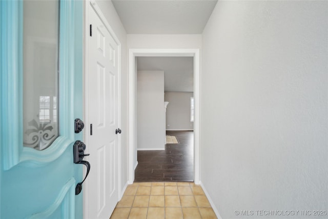 hall featuring light tile patterned floors