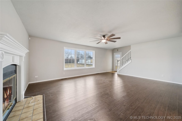 unfurnished living room with dark hardwood / wood-style flooring and ceiling fan