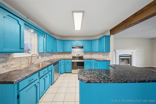 kitchen featuring blue cabinetry, sink, stainless steel appliances, a kitchen island, and light tile patterned flooring