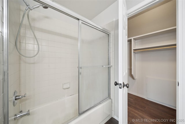 bathroom with combined bath / shower with glass door and hardwood / wood-style floors