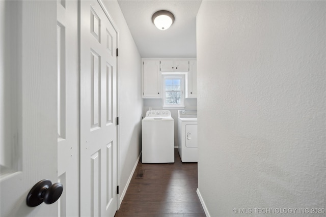 washroom featuring cabinets, washing machine and dryer, and dark wood-type flooring