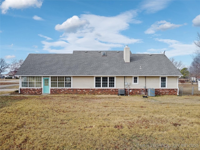 rear view of house with a yard and cooling unit