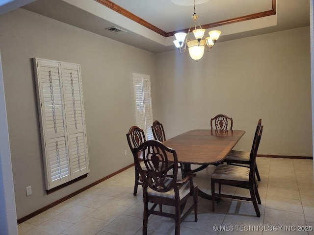 dining room with a chandelier, a tray ceiling, and ornamental molding