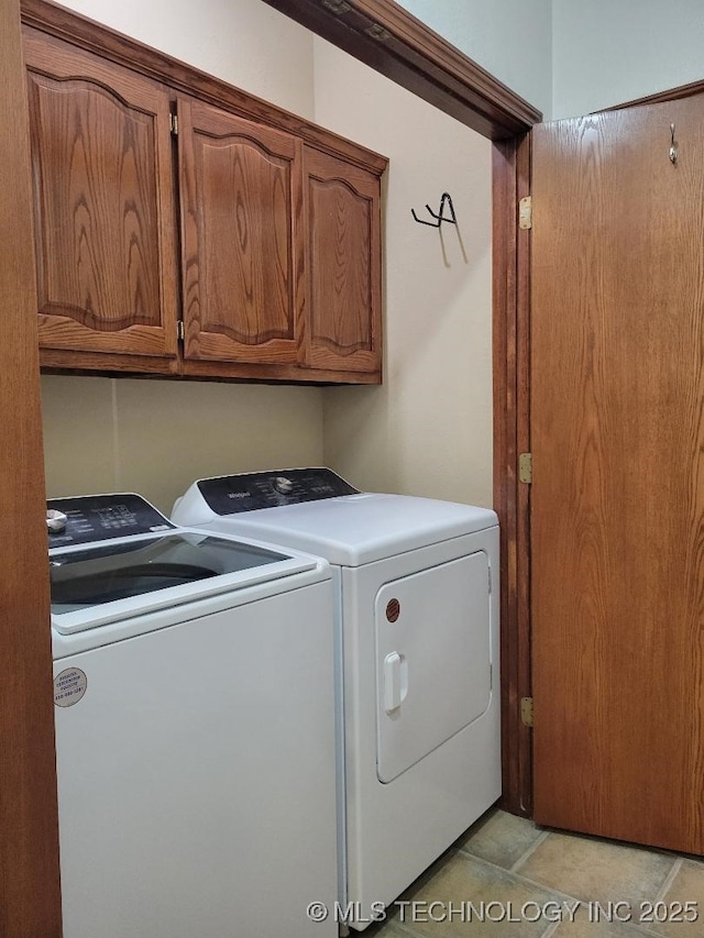 washroom with cabinets, separate washer and dryer, and light tile patterned floors