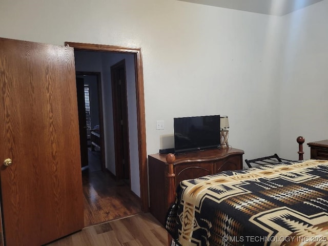 bedroom with dark hardwood / wood-style floors