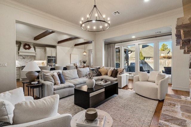 living room featuring beamed ceiling, light hardwood / wood-style floors, crown molding, and a chandelier