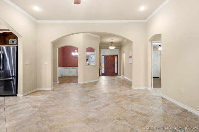 foyer featuring ceiling fan and ornamental molding