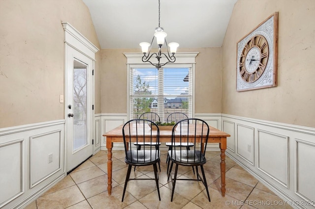 dining area with vaulted ceiling, a notable chandelier, and light tile patterned flooring