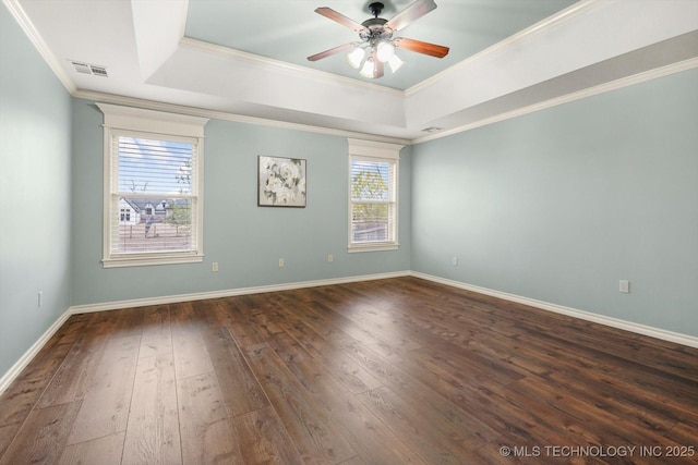 unfurnished room featuring a tray ceiling, crown molding, and dark hardwood / wood-style flooring