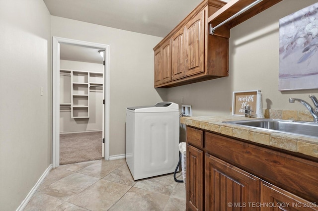 laundry area featuring cabinets, washer / dryer, light colored carpet, and sink